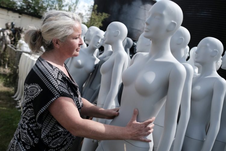 Photo of Roz Edwards who runs a successful mannequin business, next to the mannequin mountain - by Photographer PAUL-GREEVES